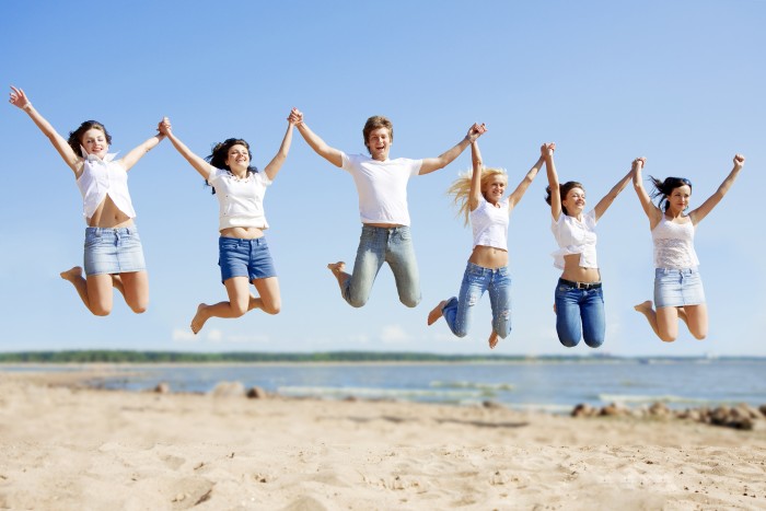 Group young friends enjoying a beach party on vacation. People h